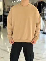 Buzo oversize color beige, con cuello redondo y diseño holgado de estilo urbano.