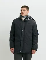 Campera de estilo Harrington en color verde oscuro, con cuello alto, cierre frontal y solapa con botones.