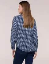 Camisa de rayón con estampado geométrico en azul y blanco, de manga larga con puños anchos abotonados y cuello camisero tradicional.