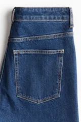 Jean de tiro alto con corte bootcut, confeccionado en denim de algodón con leve elasticidad. Presenta diseño clásico de cinco bolsillos, cierre frontal con botón y perneras ajustadas desde la cintura hasta el muslo, ensanchándose ligeramente desde la rodilla hacia el bajo.