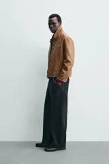 Sobrecamisa de hombre regular fit de manga larga con efecto piel en color marrón. Cuenta con cuello solapa, bolsillos de vivo en la cadera, cierre frontal con botones y puños abotonados.