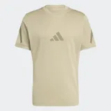 Remera Adidas de corte clásico y cuello redondo, color beige, con logo de la marca estampado en el centro del pecho y detalles gráficos en las mangas. Confeccionada en algodón fresco con protección UV.