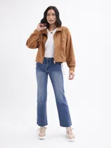 Jean de corte bootcut en color azul medio, con diseño de cinco bolsillos, cierre frontal con botón y cremallera, y bajo con terminación al corte.