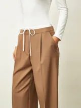 Pantalón de vestir color tostado, de corte recto y pierna ancha, con cintura elástica y cordón ajustable frontal.