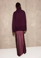 Jersey de punto de cuello alto, con diseño recto, aberturas laterales y manga larga con puños acanalados.