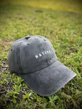 Gorra de gabardina color gris oscuro con visera curva y logo de la marca bordado en blanco en el frente.