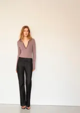 Body de manga larga color malva, con cuello tipo polo y escote en V pronunciado.