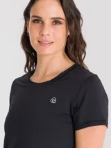 Remera deportiva de manga corta en color negro, con cuello redondo y ajuste cómodo. Presenta un pequeño logo bordado en el pecho y costuras reforzadas, diseñada con tejido técnico transpirable para mantener la frescura durante la actividad física.