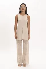 Blusa beige de tejido de punto con cuello redondo y sin mangas. Presenta un tajo central en el frente.