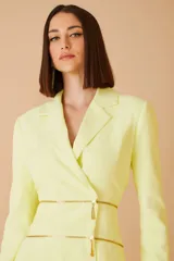 Blazer amarillo con corte entallado, solapas clásicas y cierre cruzado con cremalleras doradas.