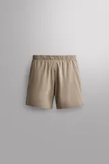 Short deportivo Zara Athleticz modelo Boulder 9", color beige, confeccionado en tejido técnico ligero y elástico. Cuenta con cintura elástica ajustable con cordón interior, bolsillos frontales y aberturas laterales en el bajo.