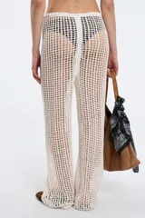 Pantalón blanco de tejido calado, con cintura elástica y cordón ajustable, de corte recto y holgado.