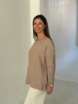 Sweater de punto color visón con diseño de trenzas horizontales, cuello redondo y mangas largas con puños acanalados.