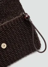 Neceser de mano marrón, con diseño trenzado y correa de muñeca con detalle de cuenta redonda.