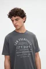 Remera de manga corta color blanco con estampa tipográfica frontal en tono rojo, de calce clásico y cuello redondo.