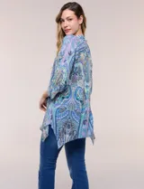 Blusa holgada de poliéster con estampado de arabescos en tonos azules, escote en V con botones frontales, mangas 3/4 y ruedo asimétrico en punta.