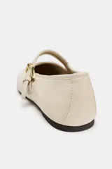 Zapato plano tipo bailarina confeccionado en piel de color crudo, con tira en el empeine y hebilla metálica dorada ajustable. Presenta puntera redonda y suela plana.