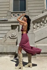 Conjunto de dos piezas color bordó, compuesto por un top halter con escote en V y ajuste elástico en la cintura, y una falda midi con volados laterales y terminaciones desflecadas.