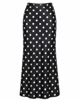 Pollera midi de seda con estampado de lunares blancos sobre fondo negro, de corte al bies y ajuste al cuerpo.