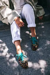 Championes de diseño artesanal con estampado animal print de leopardo. Presentan detalles en cuero color turquesa en la lengüeta, cordones, talón y collarín. Cuentan con una suela plana de goma color caramelo y una cuña interna oculta para mayor comodidad.