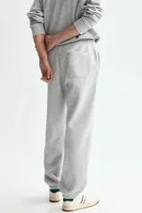 Pantalon deportivo de felpa gris claro melange, de corte relajado, con cintura elastizada y cordon de ajuste, bolsillos laterales y punos acanalados.