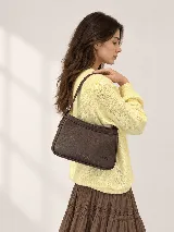 Sweater de hilo tejido color amarillo, con cuello redondo, calce cómodo y mangas amplias con puños acanalados. Presenta detalles de trenzas y flecos en el frente.