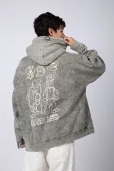 Buzo canguro oversize de algodón friza con efecto de teñido artesanal desgastado. Presenta capucha con cordones negros, bolsillo frontal tipo canguro y estampa pequeña de Popeye en el pecho.