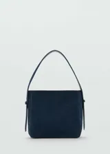 Bolso de hombro de tamaño mediano confeccionado en piel de serraje color azul marino. Cuenta con un asa corta ajustable, cierre de botón magnético y forro interior.