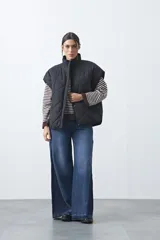 Chaleco acolchado de nylon con diseño capitoneado, cuello alto y cierre frontal con botones a presión. Presenta un calce amplio y versátil.