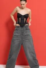 Jean de tiro bajo con corte extra oversize y pierna ancha, confeccionado en denim gris con efecto lavado localizado en la zona de la cadera.