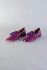 Mocasines verdes con textura símil piel de reptil y detalle de cadena plástica en el empeine.