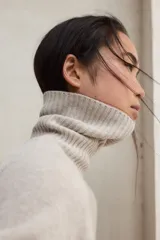 Suéter de cuello alto, color negro, de tejido de punto liso y corte holgado.