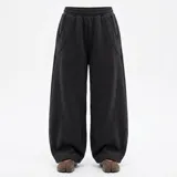 Pantalon deportivo de corte baggy y estilo oversize, confeccionado en tejido de algodón con textura afelpada. Presenta cintura elástica, bolsillos laterales y costuras decorativas verticales que recorren el frente de la prenda, aportando volumen y estructura.