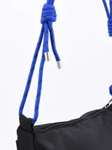 Bandolera negra de tela impermeable con correa de soga azul y detalles metálicos plateados.