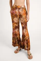 Pantalón fluido de tiro alto con estampado animal print tipo serpiente en tonos marrones y cobrizos, bolsillos laterales y perneras amplias.