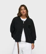 Cárdigan de punto color gris oscuro, de corte holgado y cuello redondo. Presenta cierre frontal de botones, puños y bajo elásticos, y el número 10 bordado en el pecho. Confeccionado en una mezcla de alpaca, lana y poliamida.