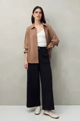 Pantalón negro de corte ancho con bolsillos delanteros con solapa.