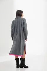 Vestido midi de tejido de punto color crema, con cuello alto, mangas largas y corte recto con aberturas laterales.