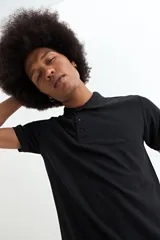 Remera tipo polo de manga corta, color negro, con cuello clásico y cierre frontal de tres botones.