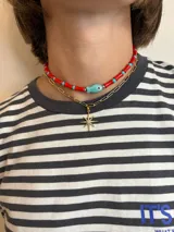 Collar corto de cuentas rojas y turquesas alternadas, con dije central de pez color turquesa.