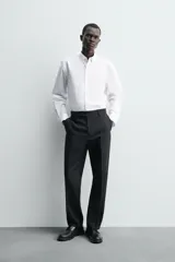 Camisa de corte regular fit confeccionada en popelín de algodón. Presenta cuello abotonado, manga larga con puños ajustables mediante botón y cierre frontal de botonadura completa.