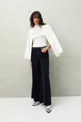 Pantalón de jean celeste de corte ultra wide, tiro medio y detalles metálicos en la cintura.