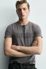 Camiseta de cuello redondo y manga corta con efecto lavado. Presenta una estampa frontal con el texto 'NOIR ECHO' en un tono más oscuro que la prenda.