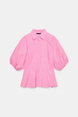 Camisa de popelín a rayas rosadas y blancas, con cuello solapa, mangas abullonadas por debajo del codo con terminación elástica, cintura entallada y bajo en evasé. Cierre frontal con botones ocultos.