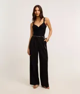 Top cropped blanco de tirantes anchos, confeccionado en tejido de punto texturizado, con escote en V y detalle de nudo o torcido en el centro del busto.