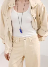 Jeans de corte wide leg en color beige, con tiro medio-alto, bolsillos clásicos y cierre frontal con botón y cremallera.