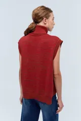 Chaleco de punto azul con cuello alto y diseño de trenzas.