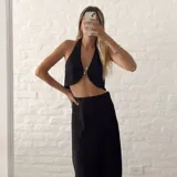 Top negro con escote halter y abertura en el centro del busto con detalle de argolla metálica.