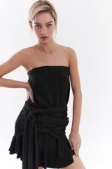 Vestido corto strapless de color negro con destellos en lúrex, de diseño recto y falda con volados.