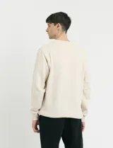 Sweater básico de cuello redondo y manga larga, confeccionado en tejido circular con puños y cuello en tejido canalé.
